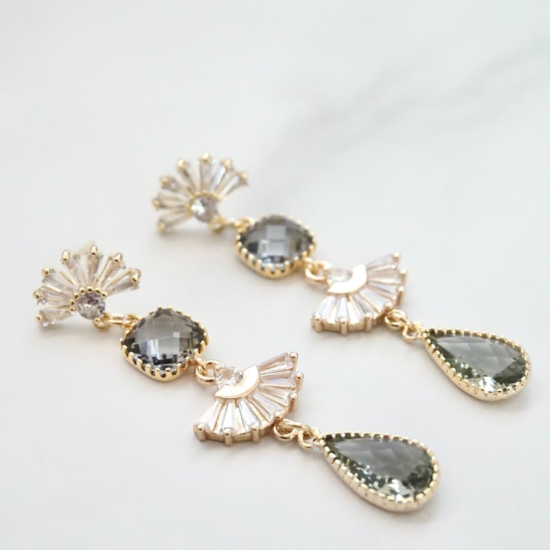 A pair of vintage looking earrings with fan shaped studs and gray stones