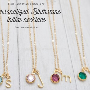 May include: Five gold necklaces with birthstone charms and initial pendants. The charms are blue, pink, purple, green, and blue. The initials are S, J, M, J, and J.
