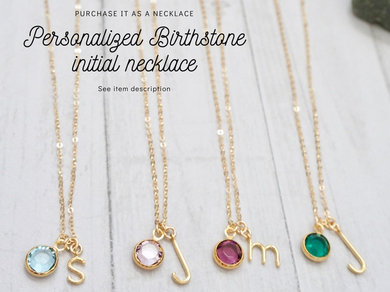 May include: Five gold necklaces with birthstone charms and initial pendants. The charms are blue, pink, purple, green, and blue. The initials are S, J, M, J, and J.