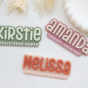 May include: Three name badges with names and titles. One is green with "Kirstie, Registered Nurse". Another is pink with "Amanda, Therapy Assistant". The last is peach with "Melissa, Speech Pathologist".