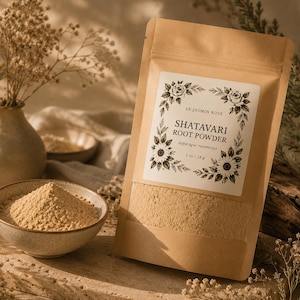 May include: A beige paper bag of Shatavari root powder with a floral label, next to a bowl of powder and a vase of dried flowers. The label reads "Shatavari Root Powder" and "1 oz / 28 g".