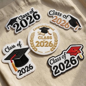 May include: A collection of embroidered patches with graduation themes. The patches feature the text "Class of 2026" in various designs, including graduation caps and a circular patch with the words "Congratulations!" and "Class of 2026".