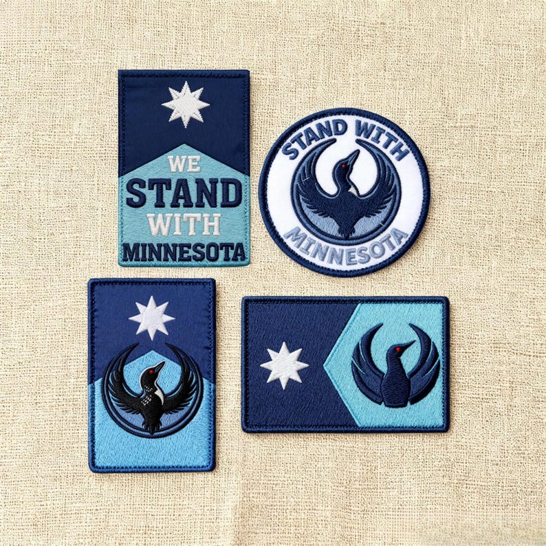 May include: Four embroidered patches with a navy blue and light blue color scheme. The patches feature a white star, a bird graphic, and the text "WE STAND WITH MINNESOTA" and "STAND WITH MINNESOTA".