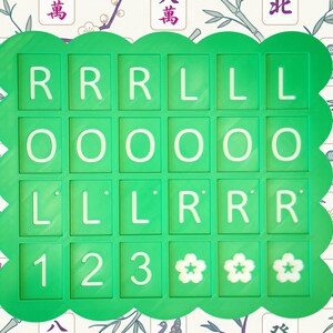 May include: A green, scalloped-edged game board with white letters and numbers. The letters spell out "RRRLLLOOOLLLRRR" and the numbers are "123" followed by three flower symbols. The background features a floral and bamboo pattern.