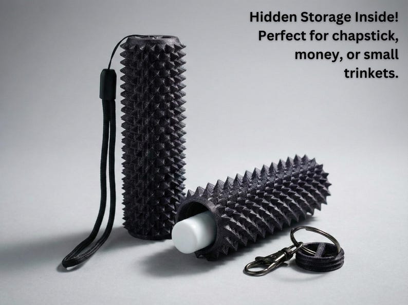 May include: Black cylindrical storage container with a textured, spiky exterior. One container is open, revealing a white object inside. Includes a black lanyard and a keyring. Text on the image reads: "Hidden Storage Inside! Perfect for chapstick, money, or small trinkets."