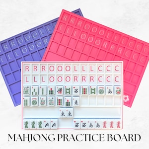 May include: Three rectangular mahjong practice boards in purple, pink, and white. The boards feature a grid layout with letters R, O, L, and C printed in the top sections. The white board is populated with various mahjong tiles featuring green and red symbols.