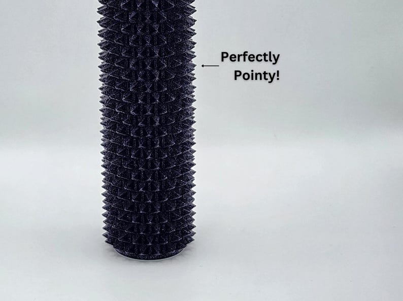 May include: A dark, cylindrical item with a textured surface featuring regularly spaced, pointed projections. The text "Perfectly Pointy!" is visible. The object is set against a white backdrop.