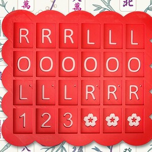May include: A red, scalloped-edge tray with individual square compartments. Each compartment contains a white letter or number. The letters spell out "ROLL LOL" and include the numbers 1, 2, and 3, along with three flower symbols.