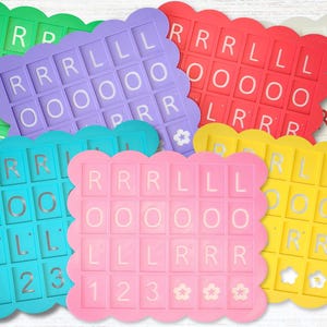 May include: A collection of colorful, scalloped-edge letter tiles in various colors, including green, purple, red, white, blue, pink, and yellow. Each tile features a grid of letters and numbers, with the letters spelling out "ROLL" and "RRR".
