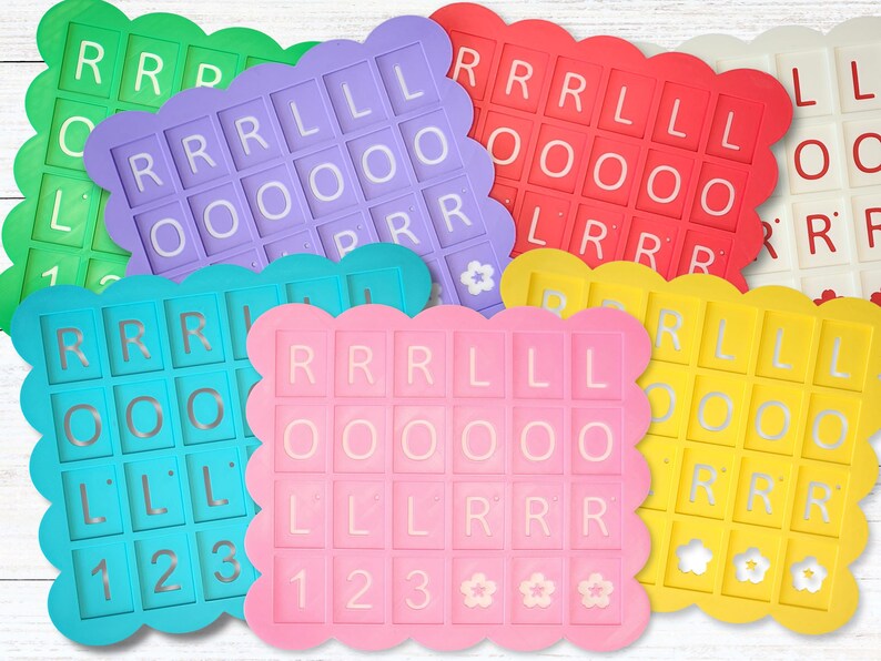 May include: A collection of colorful, scalloped-edge letter tiles in various colors, including green, purple, red, white, blue, pink, and yellow. Each tile features a grid of letters and numbers, with the letters spelling out "ROLL" and "RRR".