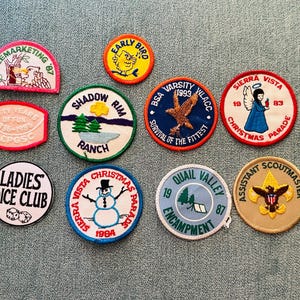 Op de afbeelding: Een verzameling vintage geborduurde patches met diverse ontwerpen en tekst. Patches zijn onder meer "Telemarketing '87", "Early Bird", "Shadow Rim Ranch", "BSA Varsity 1993", "Sierra Vista Christmas Parade" en "Ladies Dice Club".