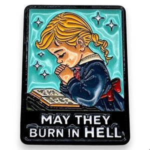 May include: A rectangular enamel pin featuring a young girl with blonde hair, praying over a book. The background is teal with white stars. The text "MAY THEY BURN IN HELL" is at the bottom.