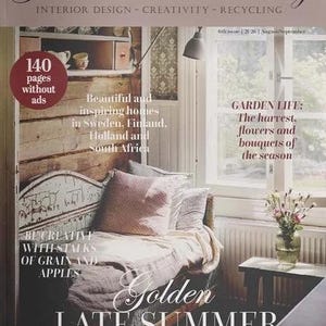 May include: The Jeanne d'Arc Living magazine cover for the 6th issue of 2020 features a room with a wooden daybed, a pink pillow, and a glass vase with flowers. Text includes "Interior Design - Creativity - Recycling" and "Golden Late Summer Magic."