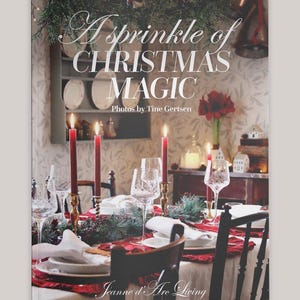 May include: A book cover titled "A Sprinkle of Christmas Magic" with a festive dining table setting. The table is set with red candles, crystal glasses, and white plates. The scene evokes a warm, holiday atmosphere.