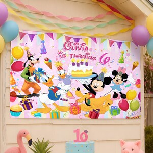Puede incluir: Una pancarta rosa de cumplea&ntilde;os con los personajes de Disney Mickey Mouse, Minnie Mouse, Donald Duck, Daisy Duck, Goofy y Pluto. La pancarta dice "Olivia cumple 6 a&ntilde;os" con confeti colorido y decoraciones de fiesta. Tambi&eacute;n se ven globos y serpentinas.