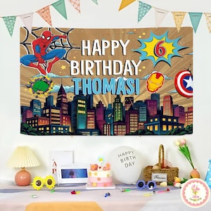 May include: A birthday banner featuring Spider-Man, the text "HAPPY BIRTHDAY THOMAS!", and a cityscape. The banner also includes the number 6, Iron Man's mask, and Captain America's shield. Party decorations are on a table.
