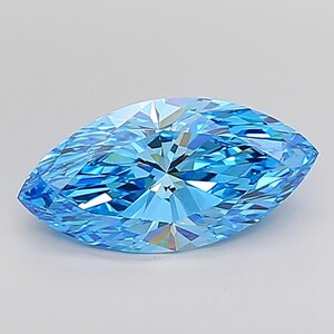 May include: A marquise-cut gemstone with a brilliant, light blue hue. The gem's facets reflect light, creating a sparkling effect. The elongated shape and color make it a striking piece for jewelry.