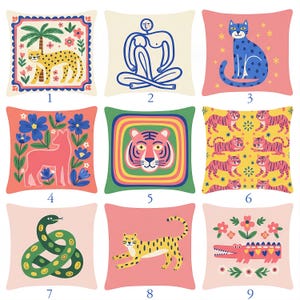 Könnte beinhalten: Neun dekorative Zierkissen mit farbenfrohen Tier- und Figurenmustern. Kissen zeigen einen Geparden, eine Figur, eine blaue Katze, ein rosa Reh, ein Tigergesicht, ein Tigermuster, eine grüne Schlange, einen laufenden Geparden und ein Krokodil.