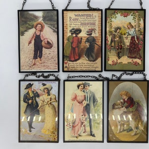 May include: Set of six vintage framed pictures with various scenes, including a boy fishing, a couple walking, a dog and a girl, and a couple standing in front of a brick wall. The frames are black with a chain for hanging.