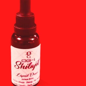 Puede incluir: Una botella de vidrio de color granate con un cuentagotas, etiquetada como "OG-1 Shilajit Liquid Drops". La etiqueta también incluye las palabras "Instant Boost" y "100% Organic". El fondo es rojo liso.