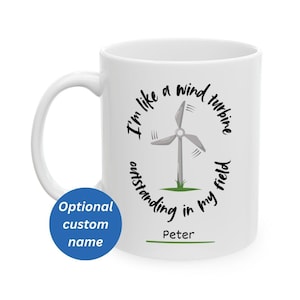 May include: White ceramic mug with a black graphic of a wind turbine and the text "I'm like a wind turbine outstanding in my field". The mug also has the name "Peter" and a blue circle that says "Optional custom name".