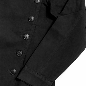 May include: Black jacket with a button-up closure and long sleeves. The jacket features a series of round, black buttons down the front and on the sleeves. The fabric appears to be a solid, dark color.
