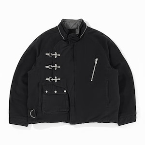 Puede incluir: Chaqueta negra con cuello alto y cierres metálicos plateados. La chaqueta tiene cierre de cremallera en el lado derecho y un pequeño bolsillo con dos botones. Un anillo en D es visible en la parte inferior izquierda. La chaqueta tiene forro gris.