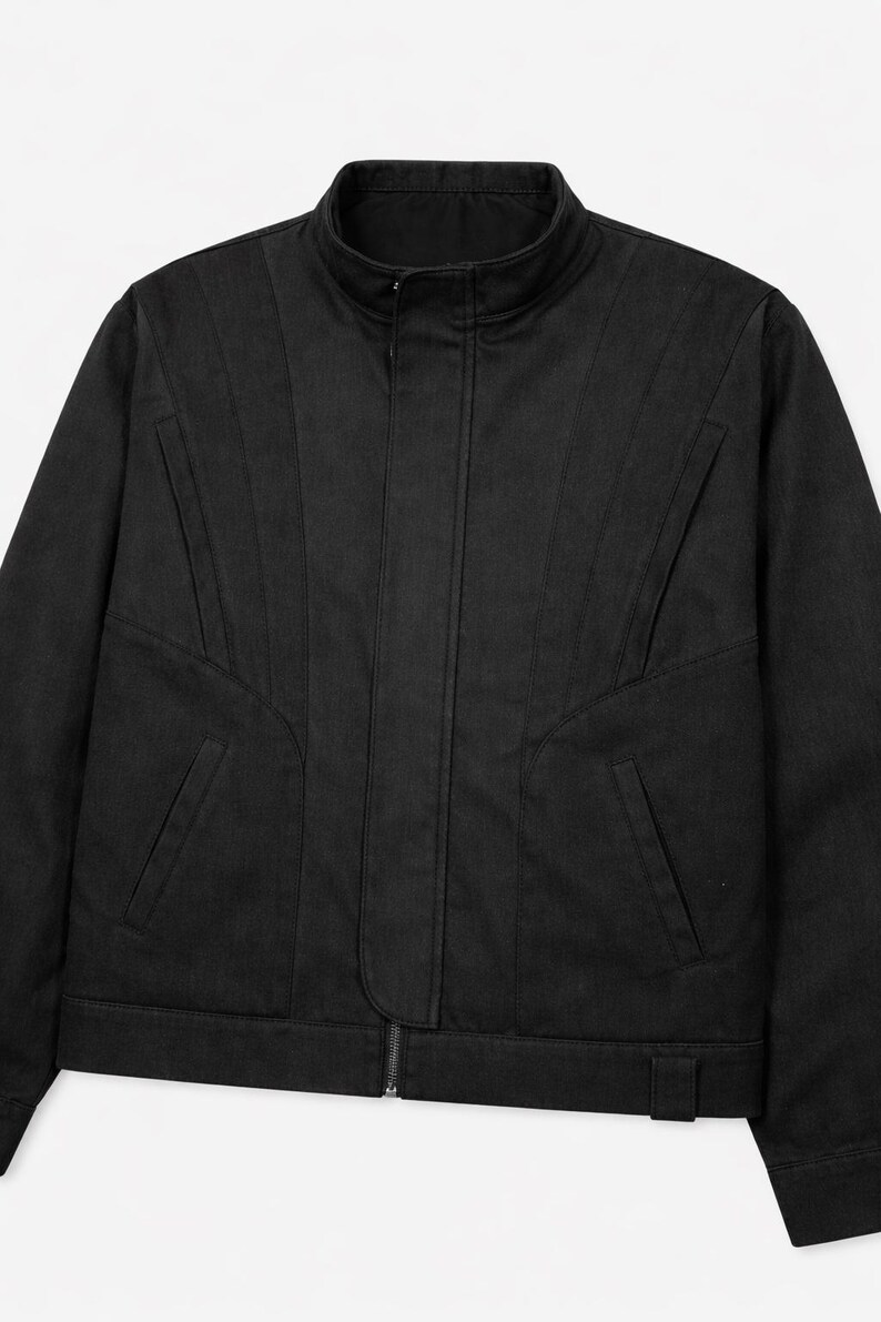 May include: Black jacket with a stand-up collar and a full-length zipper. The jacket features angled seams and two front pockets. The jacket is made of a solid black material.