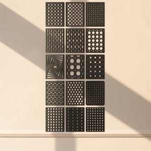 Può includere: Una collezione di pannelli decorativi neri con vari disegni geometrici e a motivi. I pannelli rettangolari sono montati su una parete di colore chiaro, creando un'esposizione moderna e artistica. I pannelli sono disposti a griglia.