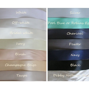 May include: A selection of satin ribbon colors for wedding decorations.  The colors include white, off-white, bridal white, ivory, blush, champagne beige, taupe, silver, pool blue or robin's egg blue, charcoal, pewter, navy, and black.