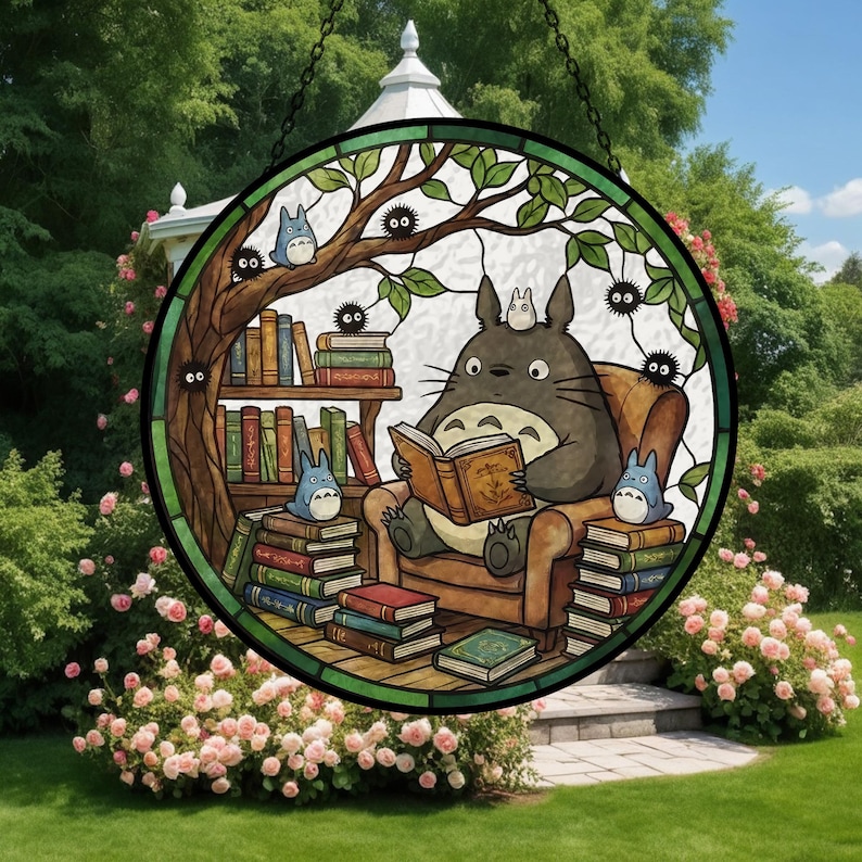 Pode incluir: Vitral redondo com um personagem de desenho animado lendo um livro, rodeado por livros e outros personagens. A janela tem uma moldura preta e uma corrente para pendurar, em um fundo de jardim. O design &eacute; circular.