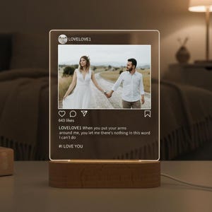 May include: A lighted acrylic panel with a photo of a couple holding hands, resembling an Instagram post. The panel is mounted on a wooden base. Text includes "LOVELOVE1" and "#I LOVE YOU".