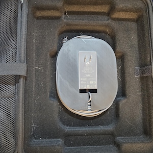 May include: A black carrying case with a gray power adapter and cord inside. The adapter has the text "X-FORCE" printed on it.