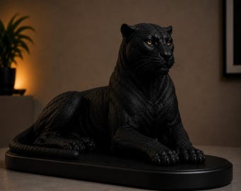 May include: A matte black panther sculpture in a resting position, featuring detailed fur texture, alert ears, and piercing amber-colored eyes. The feline figure is mounted on a matching oval black base, capturing a realistic and focused expression.