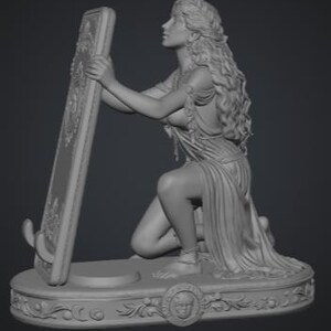 May include: A monochromatic gray resin sculpture of a figure with long flowing hair kneeling on an oval base. The figure holds a tall rectangular frame with ornate carvings. The base features a central circular emblem with a face relief.
