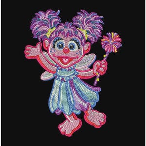 Op de afbeelding: Geborduurd beeld van een cartoon fee karakter met roze, paarse en blauwe details. De fee heeft grote ogen, een rode neus en een jurk. Ze houdt een toverstaf vast met een kleurrijke bloem erop. De achtergrond is zwart.