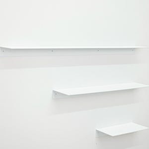 Puede incluir: Tres estantes de pared de metal blanco de longitudes variables montados horizontalmente. Cada estante cuenta con una superficie plana y una placa posterior vertical con orificios para tornillos visibles para su fijaci&oacute;n a la pared.