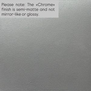 Puede incluir: Una superficie gris claro s&oacute;lida con una textura fina y uniforme. El texto en la esquina superior izquierda dice: Please note: The &laquo;Chrome&raquo; finish is semi-matte and not mirror-like or glossy. La apariencia general es neutra, plana y no reflectante.