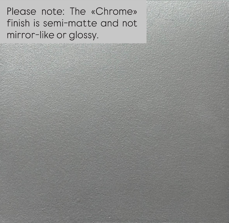 Puede incluir: Una superficie gris claro s&oacute;lida con una textura fina y uniforme. El texto en la esquina superior izquierda dice: Please note: The &laquo;Chrome&raquo; finish is semi-matte and not mirror-like or glossy. La apariencia general es neutra, plana y no reflectante.