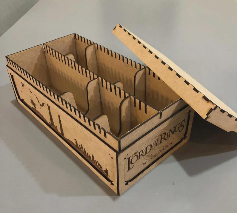 A wooden box with the Lord of the Rings logo printed on it, sitting on a gray surface.