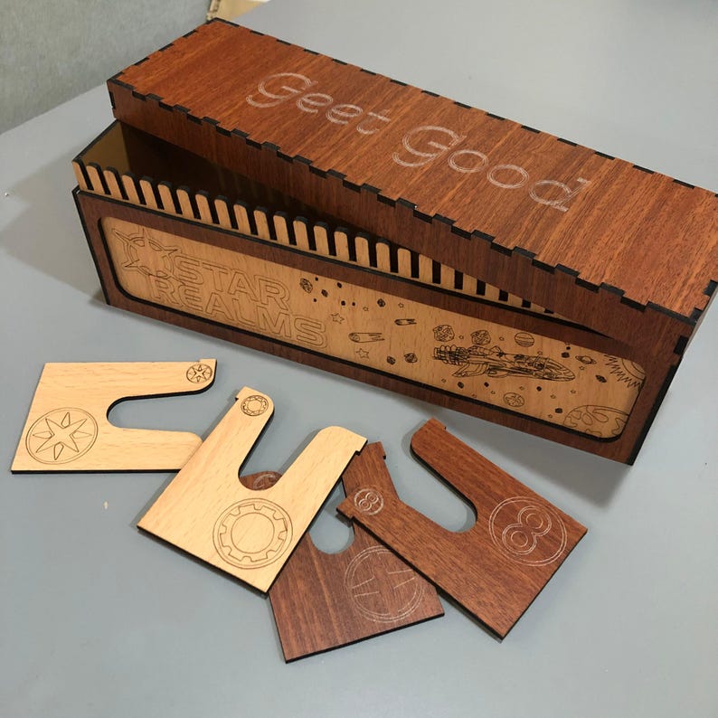 a wooden box with the phrase "Goet Good" written on it, along with various wooden pieces, including a piece with a star and a piece with a circle.