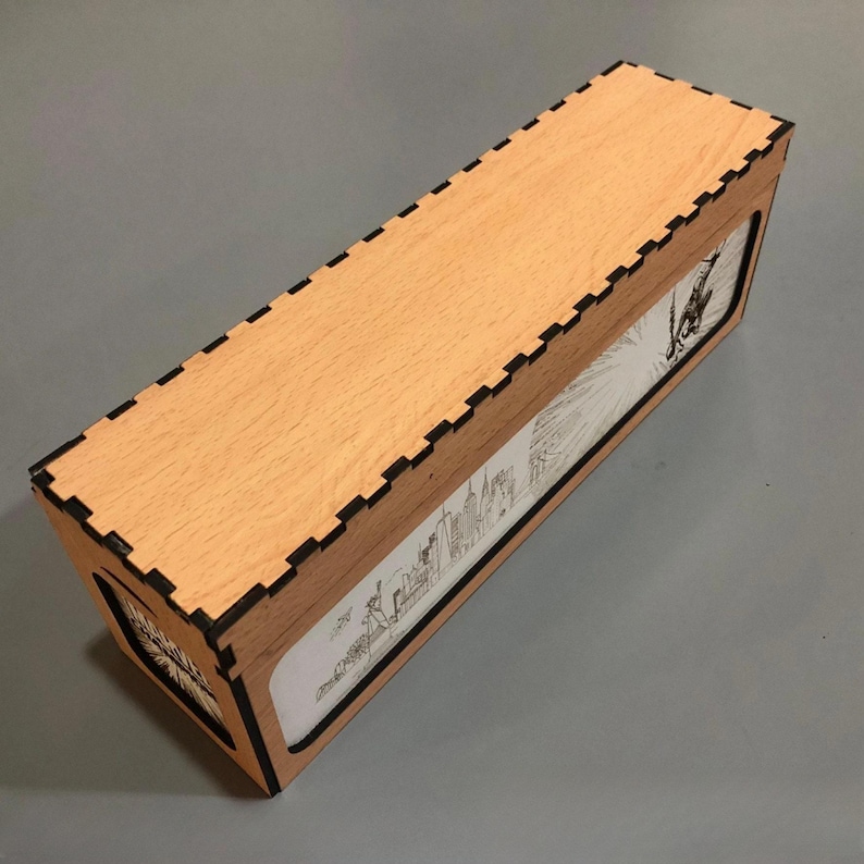 A wooden box with a lid, featuring a printed image on the front.