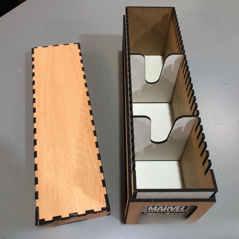 a wooden box with a cutout on the top, and a white card slot on the side, both sitting on a gray surface.