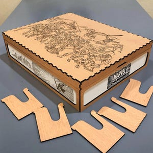 Puede incluir: Una caja de madera con un diseño de cómic grabado con láser en la tapa y los lados, con un logotipo de Marvel Champions. Incluye varios soportes de tarjetas de madera. La caja es de color marrón claro con detalles grabados en negro y acentos blancos.