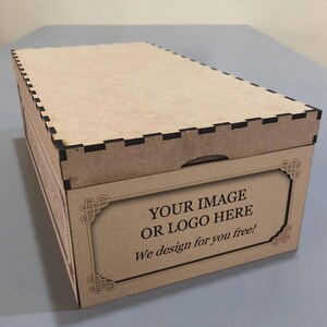 Pode incluir: Uma caixa retangular de madeira clara com tampa. A caixa tem uma borda decorativa e o texto "YOUR IMAGE OR LOGO HERE We design for you free!" é exibido na frente.