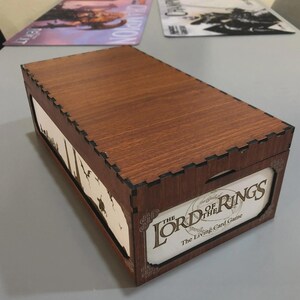 A wooden box with the title "The Lord of the Rings" printed on it, sitting on a table.