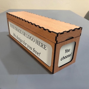 以下が含まれることがあります： 明るい木材の上面と側面を持つ長方形の木箱。箱の側面には「YOUR IMAGE OR LOGO HERE We design for you free！」というテキストが入った白いラベルが付いています。箱の端には「You choose！」というテキストがあります。