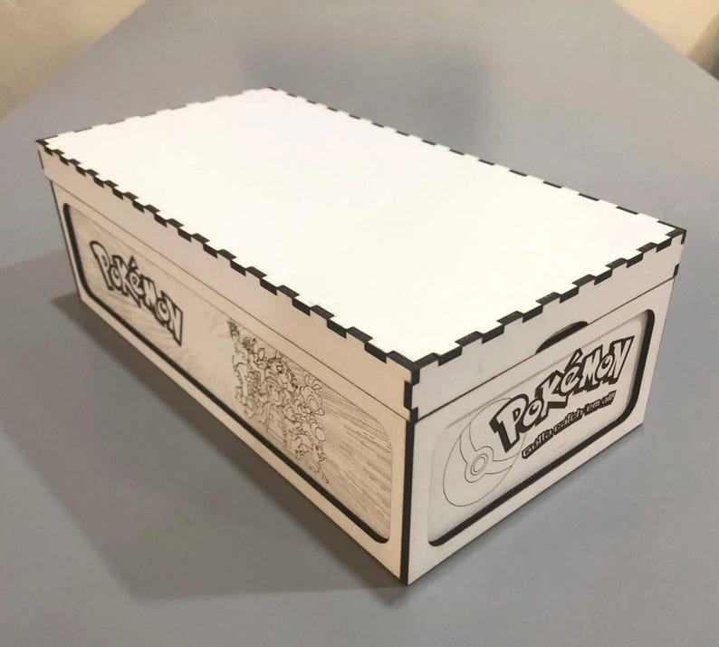 A white cardboard box with the Pokemon logo printed on it, sitting on a gray surface.