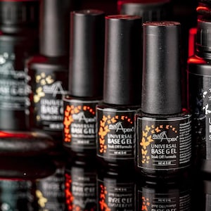 May include: A collection of black nail polish bottles with black caps. The bottles are labeled "Universal Base Gel" and "Soak Off Formula" with the brand name "nail Apex". The bottles have a butterfly design in orange and yellow.