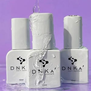 May include: Three white bottles of nail polish with the text "DNKA' nail system" and "12ml" on the labels. The bottles are sitting in water.